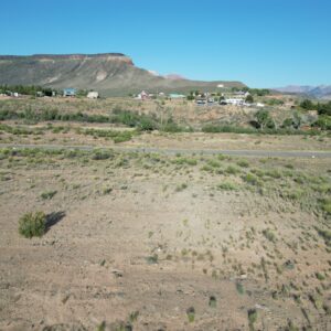 Desert landscape with mesa and rural homes.